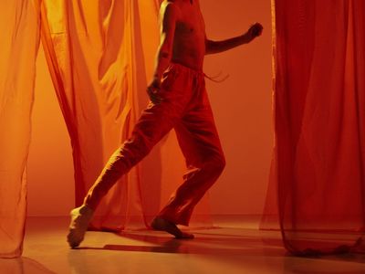 A man performing a dynamic movement in a bright space.