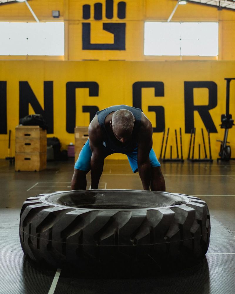 Athletic man focused on functional strength training in a minimal studio.